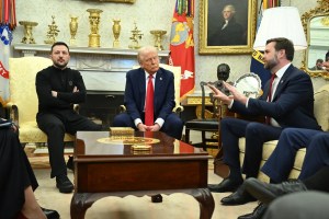 Photo of President Zelensky of Ukraine sitting in military fatigues with his arms crossed next to President Donald J. Trump sitting in a blue suit with a red tie, and J. D. Vance sitting in a blue suit on a couch berates Zelensky.